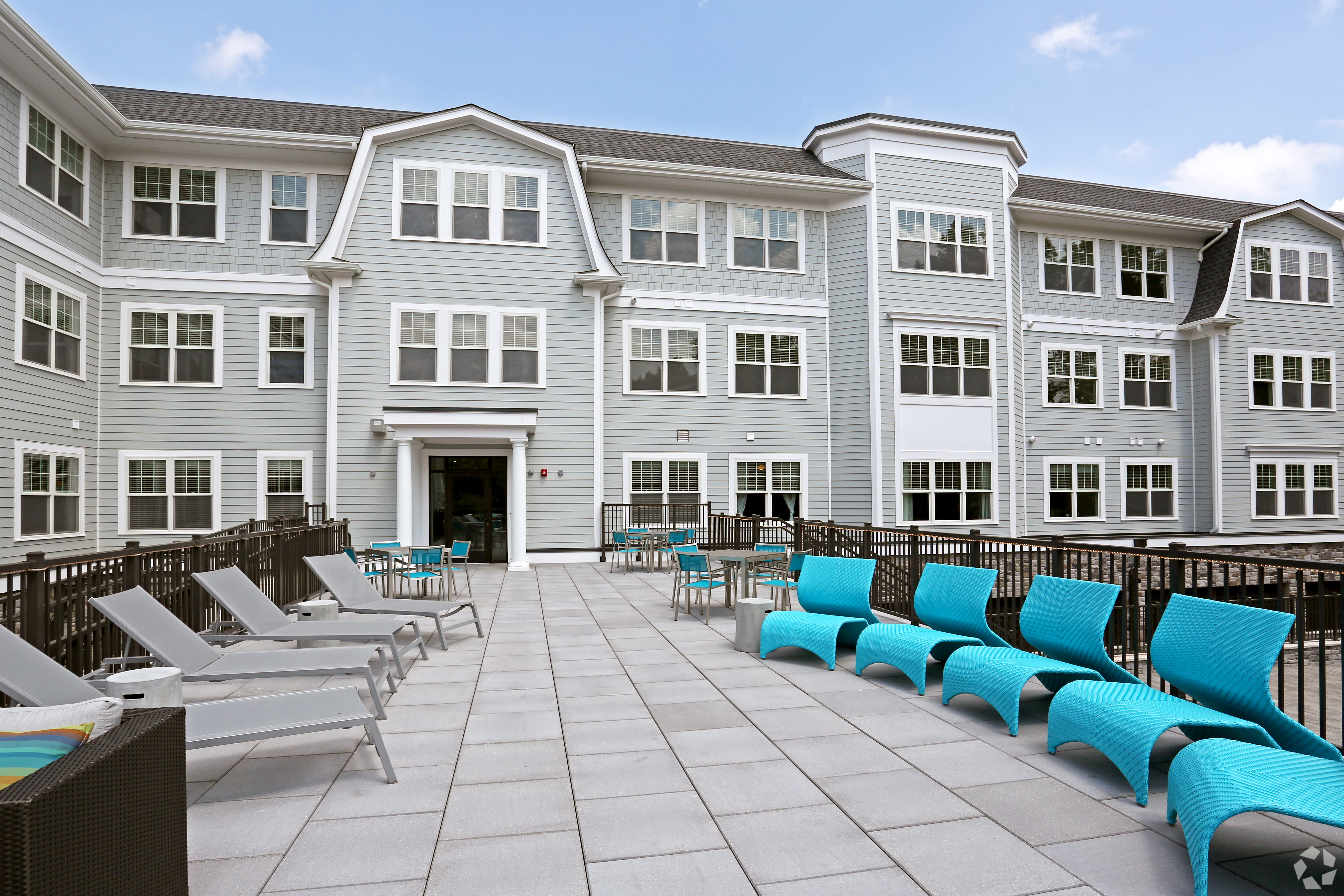 Outdoor patio with teal chaise lounges and bistro seating